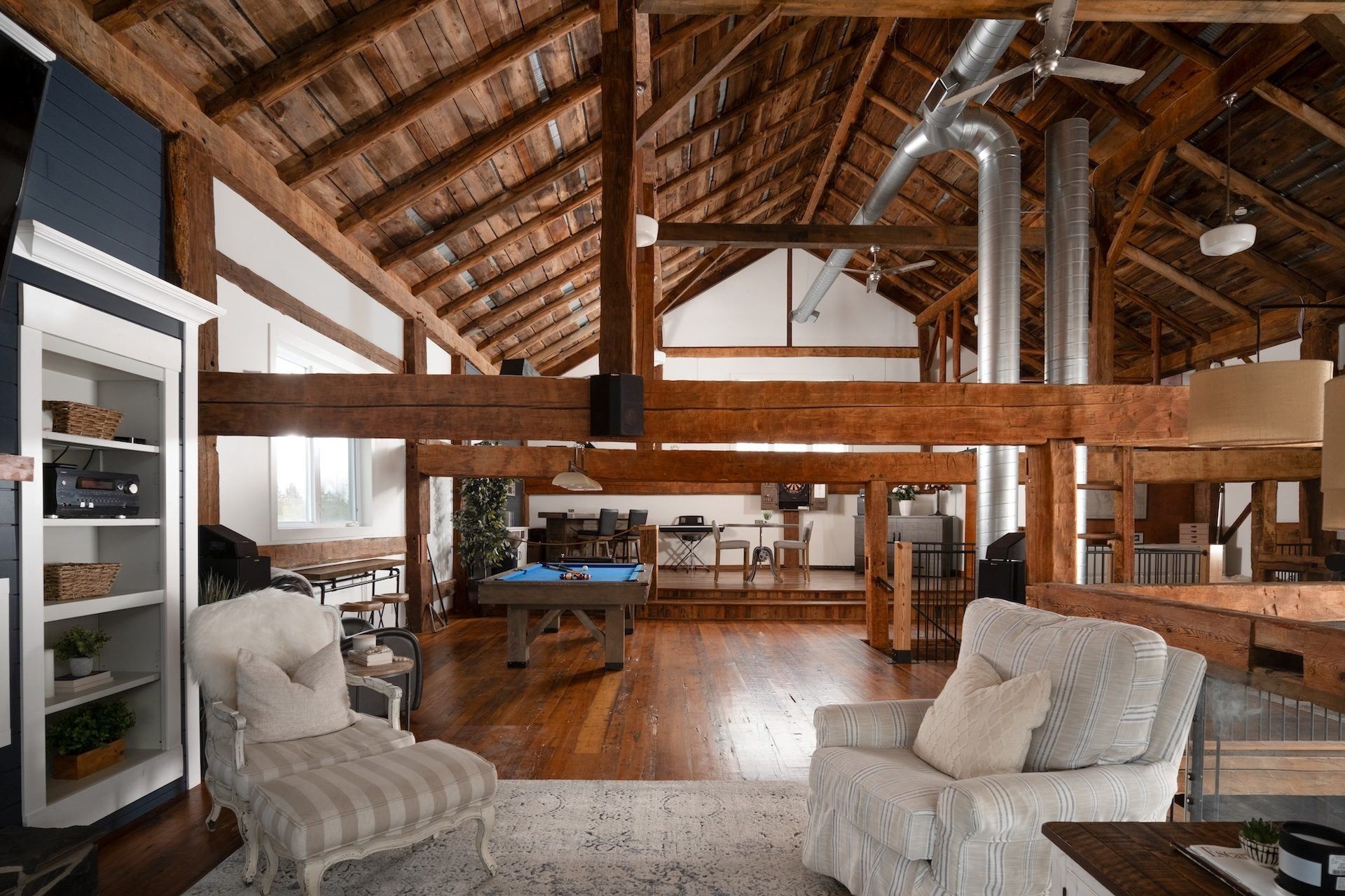 Existing furnished barn interior with exposed timber framing and open mezzanine